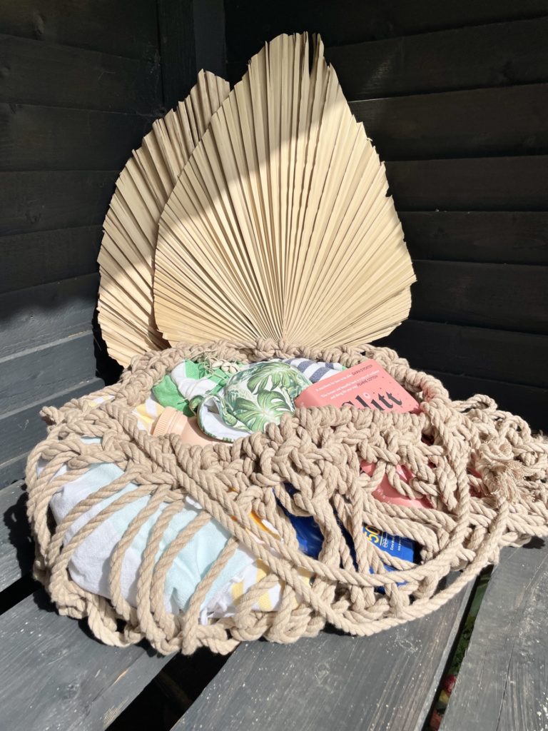 Macrame Beach bag with beach items on a bench in a beach hut