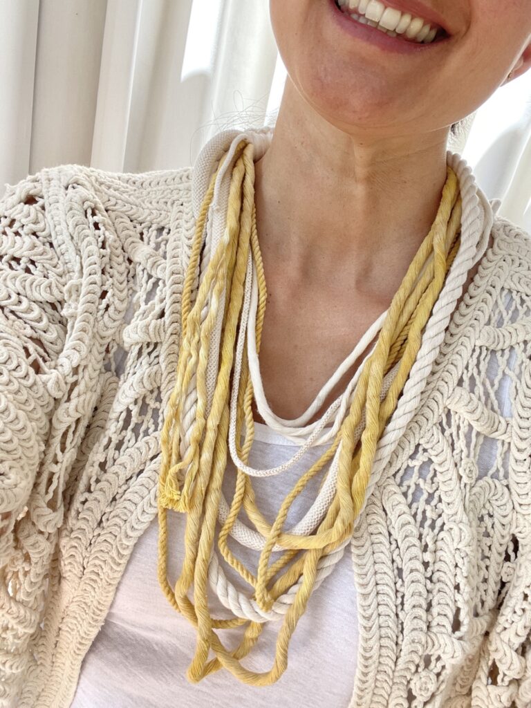 Isabella wearing a natural dyed macrame necklace in natural and yellow shades