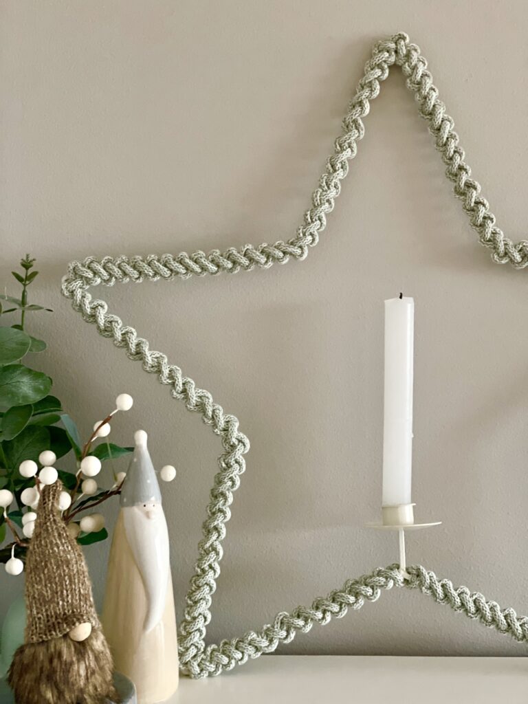macrame star of sage colour cord with a candle